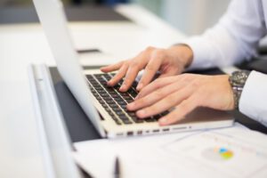 Detailaufnahme von Händen, die an einem Laptop arbeiten
